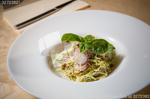 Image of Salad from cabbage, herbs, cucumber and radish in bowl.