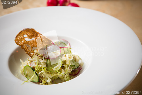 Image of Salad from cabbage, herbs, cucumber and radish in bowl.