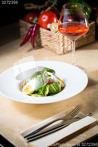 Image of plate of spring mix salad with strawberry, eggs and tuna