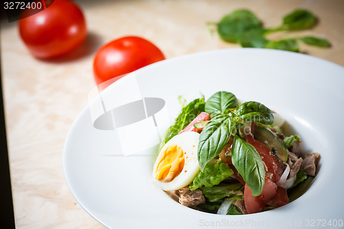 Image of plate of spring mix salad with strawberry, eggs and tuna