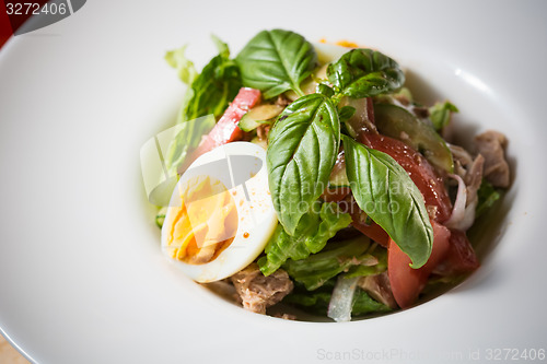 Image of plate of spring mix salad with strawberry, eggs and tuna