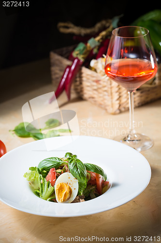 Image of plate of spring mix salad with strawberry, eggs and tuna