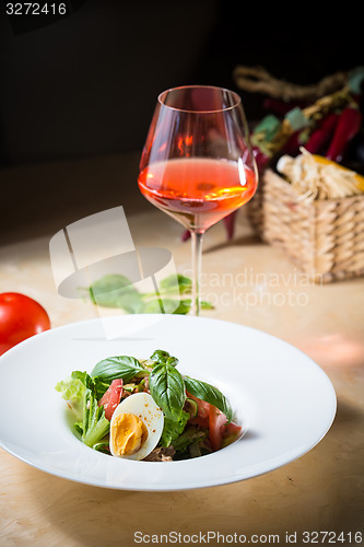 Image of plate of spring mix salad with strawberry, eggs and tuna