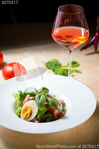 Image of plate of spring mix salad with strawberry, eggs and tuna