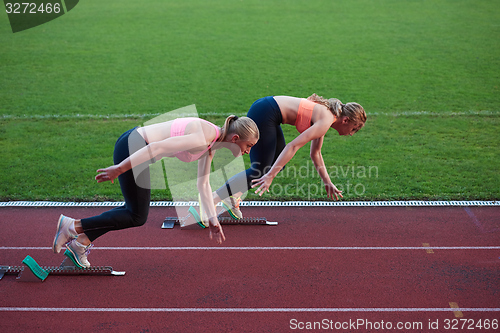 Image of athlete woman group  running on athletics race track