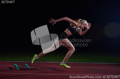 Image of woman  sprinter leaving starting blocks