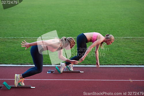 Image of athlete woman group  running on athletics race track