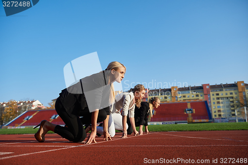 Image of business people running on racing track