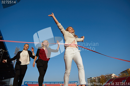 Image of business people running on racing track