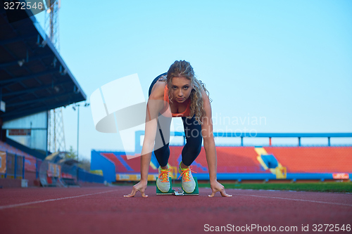 Image of woman  sprinter leaving starting blocks