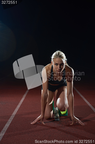 Image of woman  sprinter leaving starting blocks