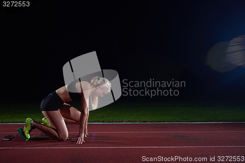 Image of woman  sprinter leaving starting blocks