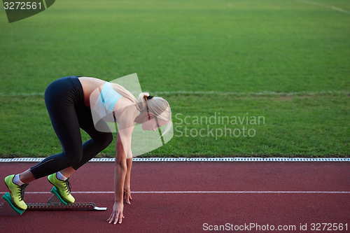 Image of woman  sprinter leaving starting blocks