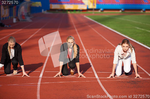 Image of business people running on racing track