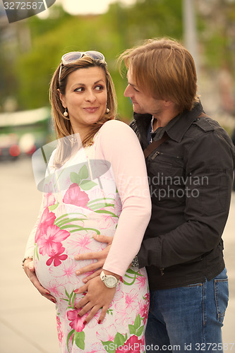 Image of young pregnant couple have fun and relax