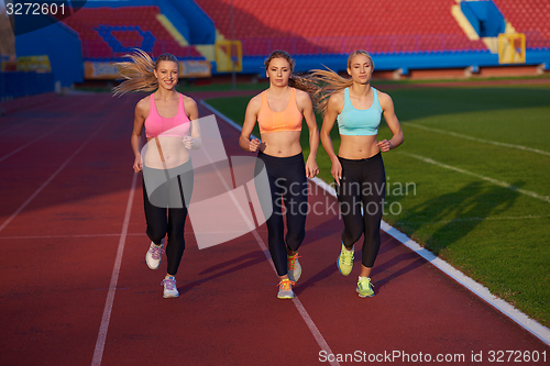 Image of athlete woman group  running on athletics race track