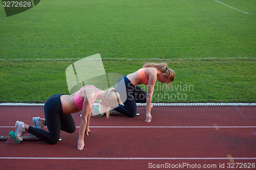 Image of athlete woman group  running on athletics race track