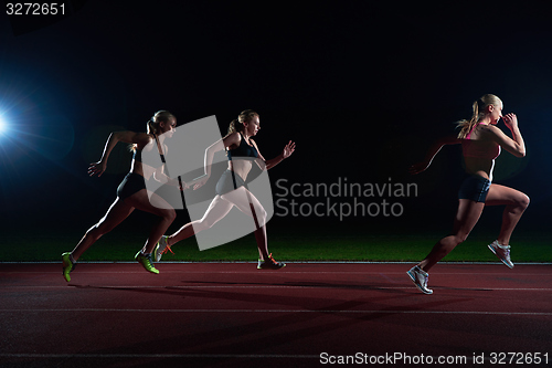 Image of athletic runners passing baton in relay race