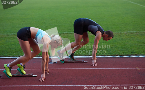 Image of athlete woman group  running on athletics race track