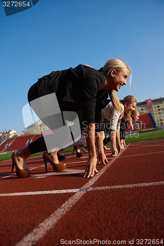 Image of business people running on racing track