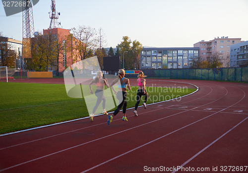 Image of athlete woman group  running on athletics race track