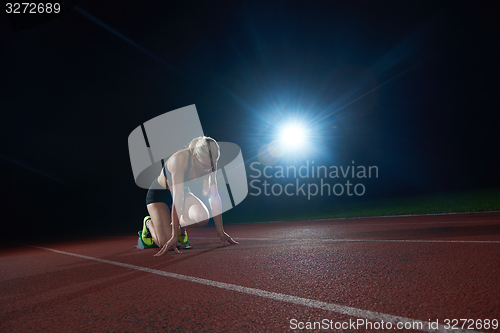 Image of woman  sprinter leaving starting blocks