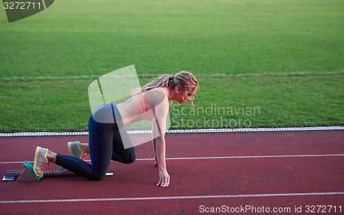 Image of woman  sprinter leaving starting blocks