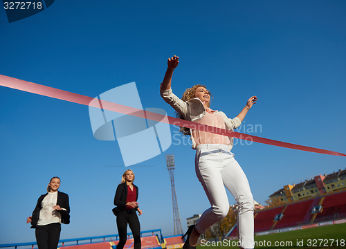 Image of business people running on racing track