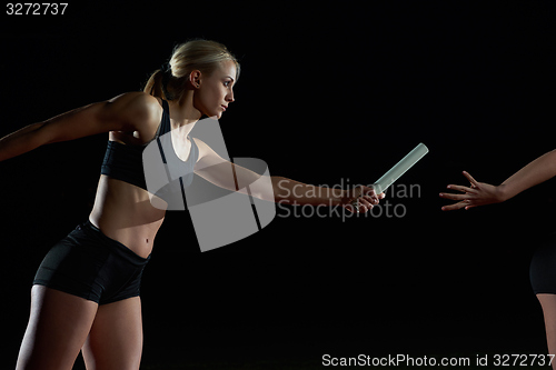 Image of athletic runners passing baton in relay race