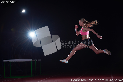 Image of Athletic woman running on track