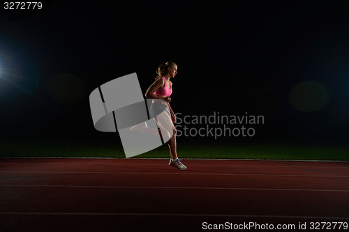 Image of Athletic woman running on track