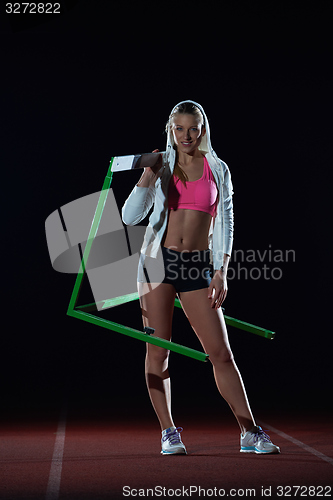 Image of woman athlete jumping over a hurdles