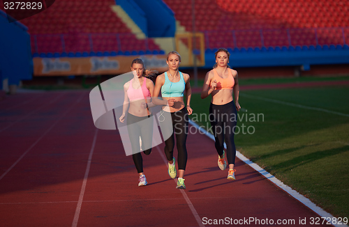 Image of athlete woman group  running on athletics race track