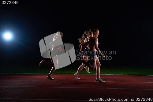 Image of athletic runners passing baton in relay race