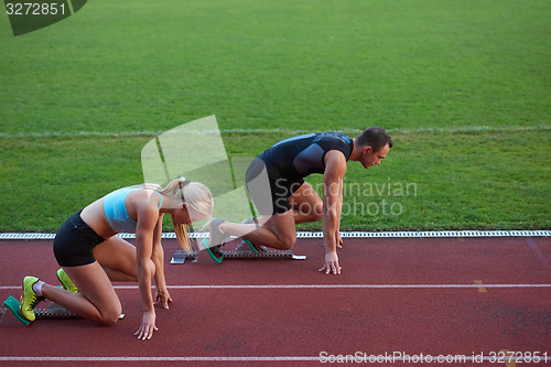 Image of athlete woman group  running on athletics race track