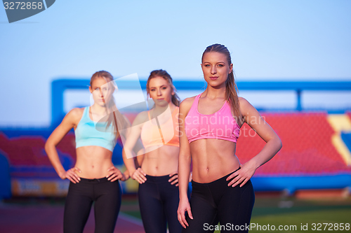 Image of athlete woman group  running on athletics race track