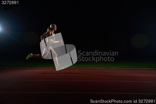 Image of Athletic woman running on track