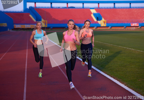 Image of athlete woman group  running on athletics race track