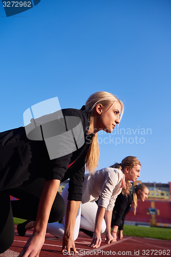 Image of business people running on racing track