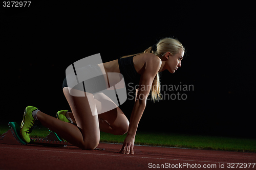 Image of woman  sprinter leaving starting blocks