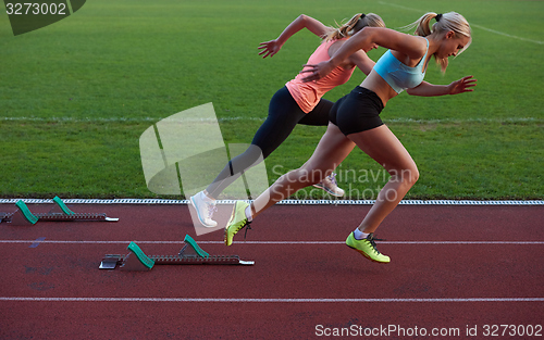 Image of woman  sprinter leaving starting blocks