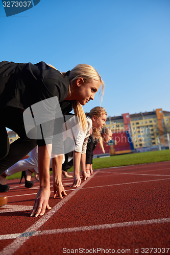 Image of business people running on racing track