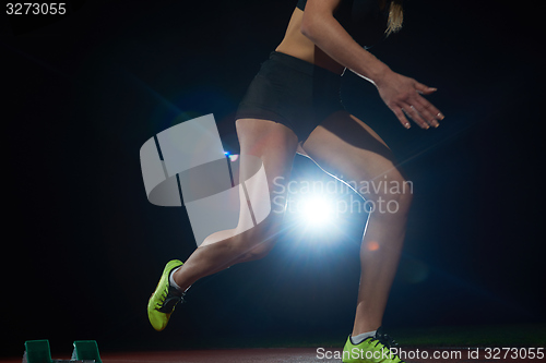 Image of woman  sprinter leaving starting blocks