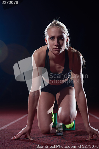 Image of woman  sprinter leaving starting blocks