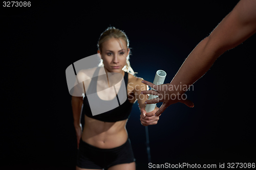 Image of athletic runners passing baton in relay race