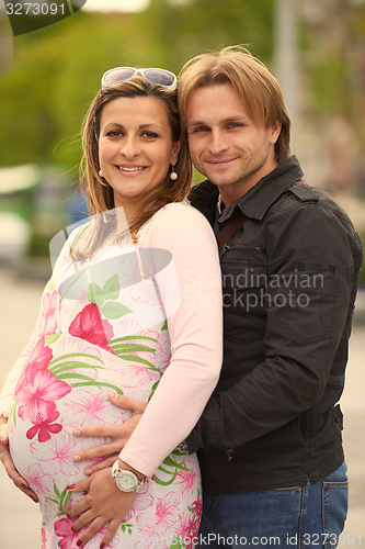 Image of young pregnant couple have fun and relax