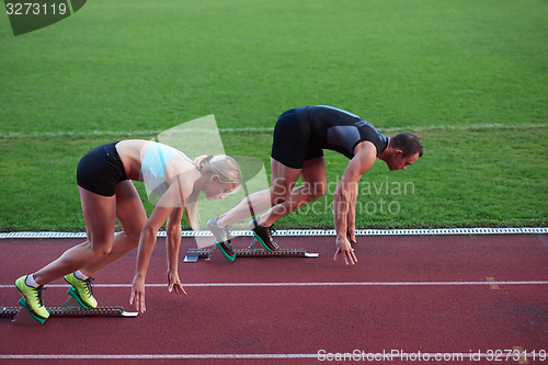 Image of athlete woman group  running on athletics race track