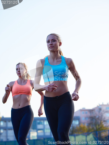 Image of athlete woman group  running on athletics race track
