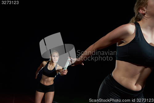 Image of athletic runners passing baton in relay race