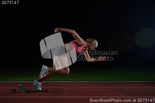 Image of woman  sprinter leaving starting blocks